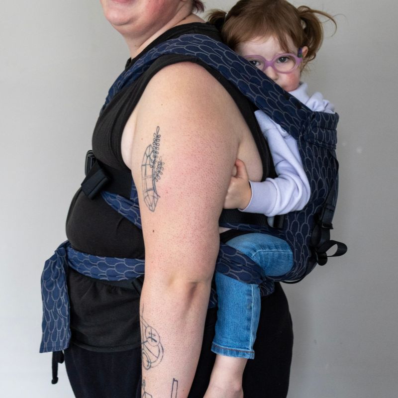 Babuebaby Gogo baby carrier in Scales worn on the back with baby supported, side view