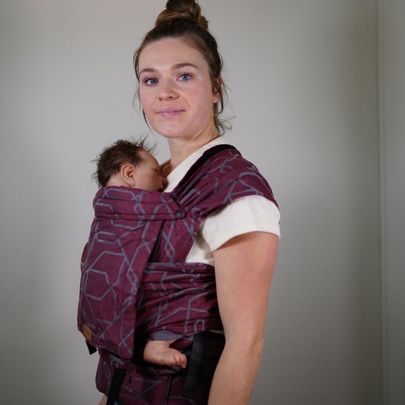 Babuebaby Mbereko baby carrier in jasper worn on the front with baby supported, side view Babuebaby Mbereko baby carrier in jasper worn on the front with baby supported, side view