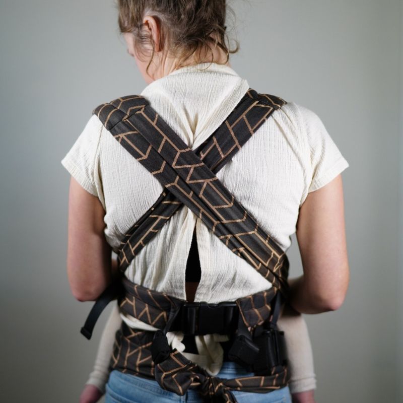 Babuebaby carrier in fractal worn on the front with baby supported, x configuration on back